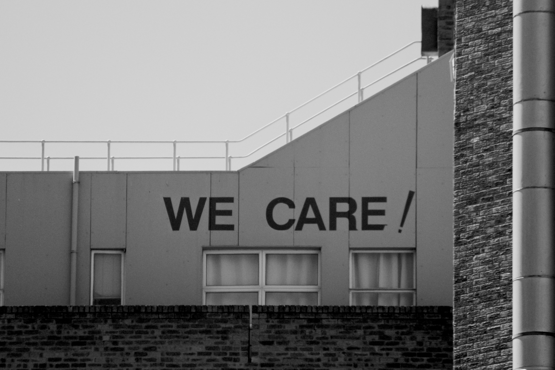 Building facade with 'WE CARE !' painted in bold letters